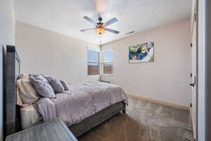 Bedroom featuring ceiling fan, a textured ceiling, and carpet flooring