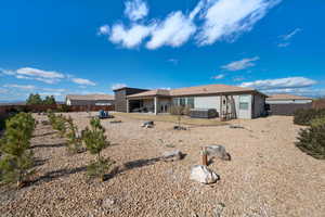 Back of property with a hot tub and a patio