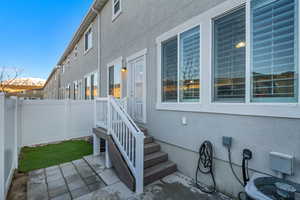 Entrance to property with a patio area and central air condition unit