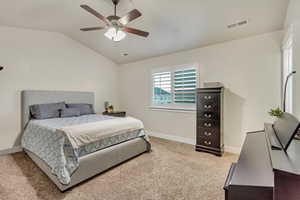 Carpeted bedroom with lofted ceiling and ceiling fan