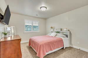 Carpeted bedroom featuring a textured ceiling