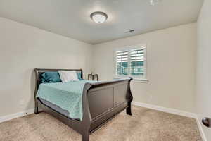 Carpeted bedroom with a textured ceiling