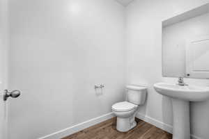 Bathroom featuring hardwood / wood-style flooring, sink, and toilet