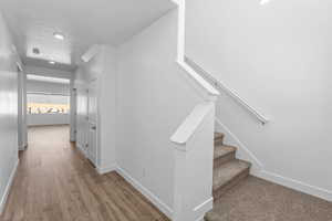 Stairs with hardwood / wood-style flooring and a textured ceiling