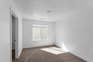 Carpeted empty room with a textured ceiling