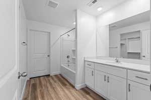 Bathroom featuring vanity, hardwood / wood-style flooring, and shower / bath combination