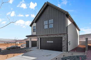 View of front of home with a mountain view and a garage