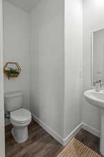 Bathroom featuring wood-type flooring and toilet