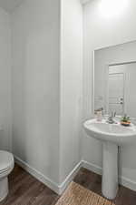 Bathroom with wood-type flooring, sink, and toilet