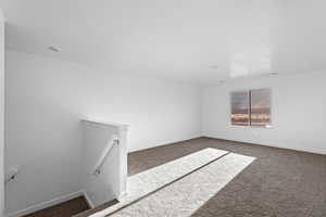 Unfurnished room with dark colored carpet