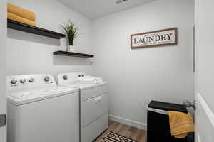 Laundry area with washing machine and dryer and dark hardwood / wood-style flooring