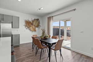 Dining area featuring dark wood-type flooring and a textured ceiling