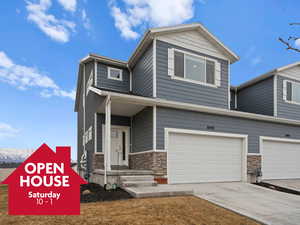 View of front of home with a garage, stone siding, a mountain view, and concrete driveway