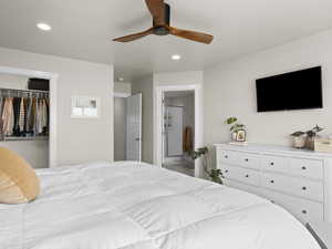 Bedroom featuring ceiling fan, connected bathroom, and a closet