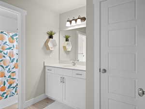 Bathroom with a shower with curtain, vanity, and wood-type flooring