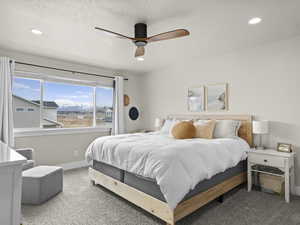 Bedroom featuring ceiling fan, carpet, and a textured ceiling