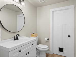 Bathroom with vanity, hardwood / wood-style flooring, and toilet