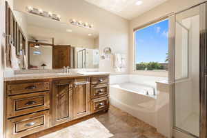 Bathroom featuring tile patterned flooring, shower with separate bathtub, vanity, and ceiling fan