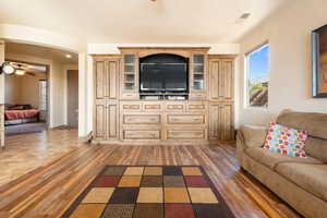 Living room with dark hardwood / wood-style flooring and ceiling fan