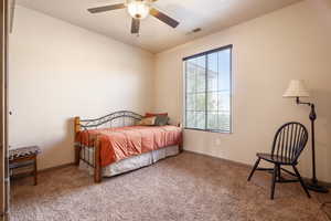 Carpeted bedroom featuring ceiling fan