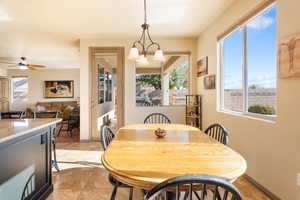 Dining area featuring ceiling fan with notable chandelier and a wealth of natural light