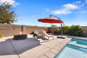 View of swimming pool with an in ground hot tub, a patio area, and a fire pit