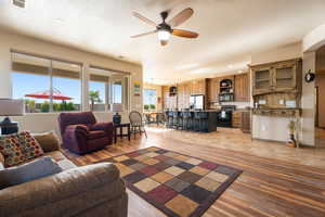 Living room with sink, a textured ceiling, light hardwood / wood-style flooring, and ceiling fan