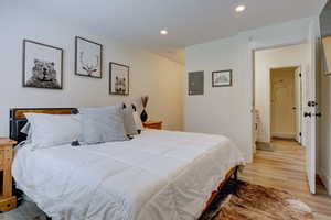 Bedroom featuring electric panel and light hardwood / wood-style floors