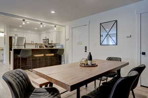 Dining room featuring light hardwood / wood-style floors, sink, and a textured ceiling