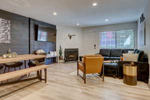 Living room with a fireplace, light hardwood / wood-style floors, and a textured ceiling