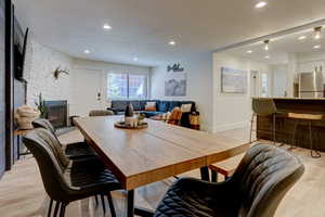 Dining area featuring a fireplace, light hardwood / wood-style floors, and a textured ceiling