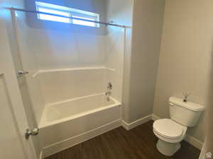 Bathroom featuring wood-type flooring, toilet, and bathing tub / shower combination