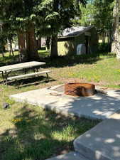 View of property's community featuring a picnic bench and fire pit