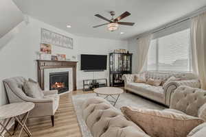 Living room with light hardwood / wood-style floors and ceiling fan