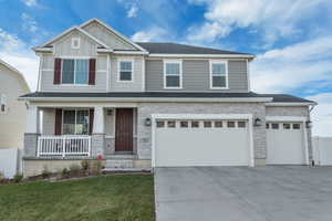 Craftsman house with a garage, a porch, and a front yard