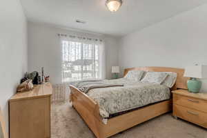 Bedroom featuring light carpet