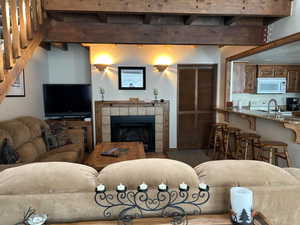 Living room featuring a fireplace, beam ceiling