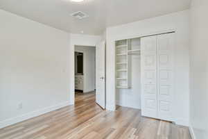 Unfurnished bedroom with a closet and light hardwood / wood-style flooring