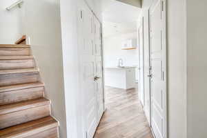 Staircase with hardwood / wood-style flooring and sink