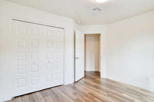 Unfurnished bedroom featuring a closet and light wood-type flooring