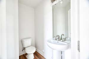 Bathroom with hardwood / wood-style flooring, sink, and toilet