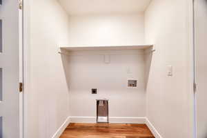 Laundry area with electric dryer hookup, washer hookup, and light hardwood / wood-style floors