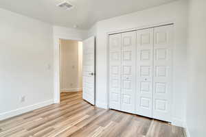 Unfurnished bedroom with a closet and light hardwood / wood-style flooring