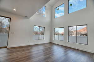 Unfurnished living room featuring dark hardwood / wood-style flooring and a mountain view