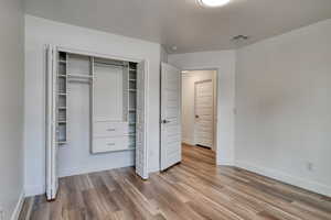 Unfurnished bedroom with hardwood / wood-style flooring and a closet