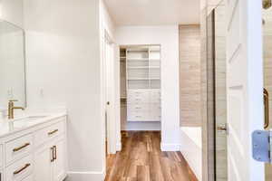 Bathroom featuring vanity, hardwood / wood-style flooring, and separate shower and tub