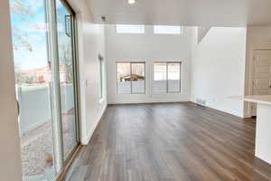 Unfurnished living room with dark wood-type flooring