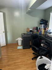 Office area featuring a textured ceiling and light wood-type flooring