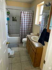 Full bathroom with tile patterned flooring, vanity, shower / bath combination with curtain, and toilet