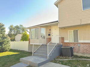 View of front of house featuring central AC and a front yard